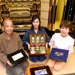 箱型に職人技の粋を集めた「漆恵」と、考案した原田真一郎社長（左）ら家族＝姫路市米田町、原田光明堂