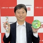 代替チーズの開発、大阪・関西万博での提供を発表した記者懇談会で、新商品をＰＲする六甲バターの塚本浩康社長（同社提供）
