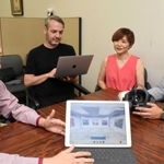 タブレットやＶＲゴーグルを手に、メタバース事業について話すシマフジＩＥＭの島藤真澄ＣＥＯ（左から３人目）ら。海外出身のエンジニアも活躍している＝神戸市中央区港島中町６