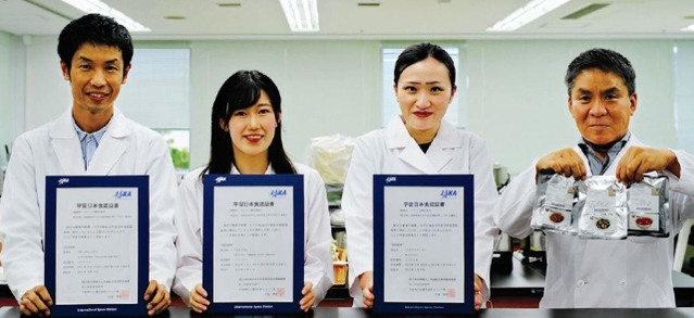 宇宙日本食の認証書を手にするフジッコの開発担当者ら（フジッコ提供）