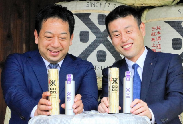 「沢の鶴　ＮＡＤＡ８８」を手にする西村隆・沢の鶴社長（右）と山岡照幸・ヤンマーマルシェ社長＝神戸市灘区大石南町１、沢の鶴資料館