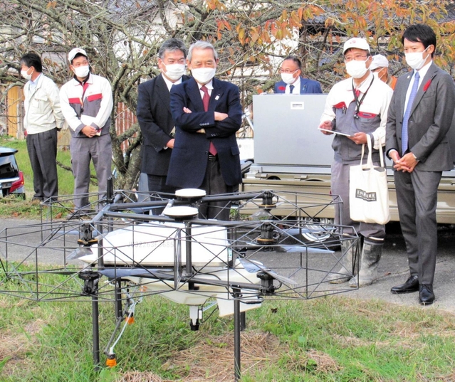 農薬散布に使うドローンの説明を聞く関経連の松本正義会長（左から４人目）と、兵庫県の斎藤元彦知事（右端）＝丹波篠山市大山上