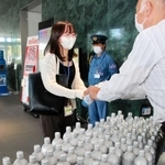 アルミボトル缶入りの水を受け取る徒歩帰宅訓練の参加者＝神戸市中央区脇浜海岸通２、神戸製鋼所神戸本社