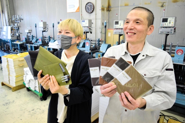 独自ブランドのノートを開発した村井製本所の村井広治社長（右）と、ノートに合わせたケースを作った革小物作家の清冨雅子さん＝神戸市兵庫区和田山通１