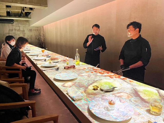 支配人の大坪健次さん（右から２人目）が語り部として、神戸の食を紹介する＝神戸市中央区北長狭通２