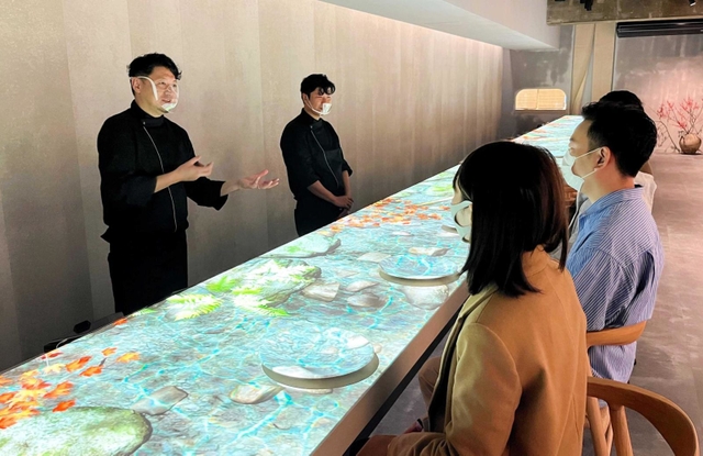 支配人の大坪健次さん（左）が語り部として、神戸の食を紹介する＝神戸市中央区北長狭通２