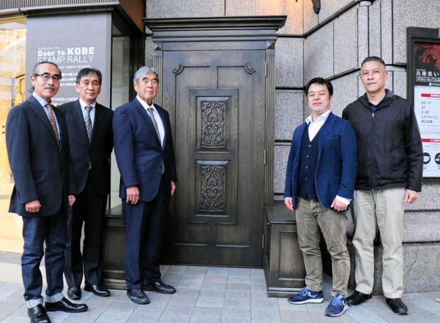 神戸洋家具の特徴あるデザインのドアの前に立つ兵庫県家具組合連合会のメンバー＝神戸市中央区明石町４０