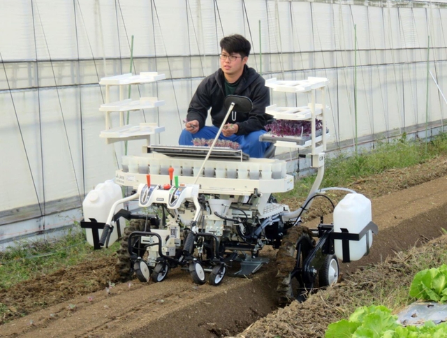 式典後、半自動の野菜移植機を実演操作する学生（兵庫県立農業大学校提供）