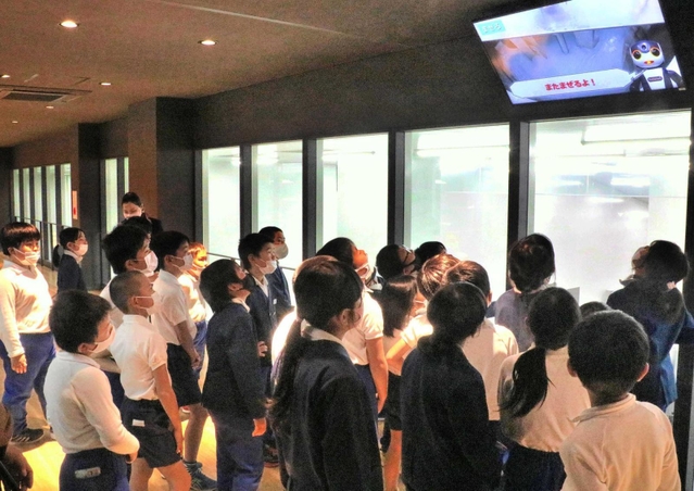 新たに整備した見学通路から製造工程を見学する福崎小の児童ら＝兵庫県福崎町高橋、マンダム福崎工場