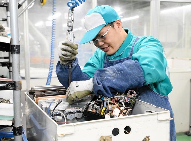 就労継続支援Ａ型事業所「すまいるハーツ」で行われている給湯器の分解作業＝兵庫県稲美町国安（ノーリツ提供）