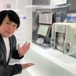 「魚群探知機の日」登録に尽力した古野電気の高津みなとさんと初代の魚群探知機＝西宮市芦原町、同社