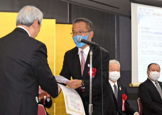関西経済連合会の松本正義会長から表彰される早駒運輸の渡辺真二社長＝大阪市北区、大阪府立国際会議場