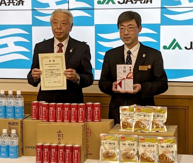 ＪＡ共済連兵庫運営委員会の福本博之会長（左）から備蓄食料の寄付を受けた兵庫県の遠藤英二防災監＝県災害対策センター（県提供）