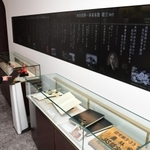 伊藤ハムの年表を映すモニターと、展示される伊藤傳三氏や伊藤ハムゆかりの品々＝神戸市灘区備後町３、伊藤傳三記念館