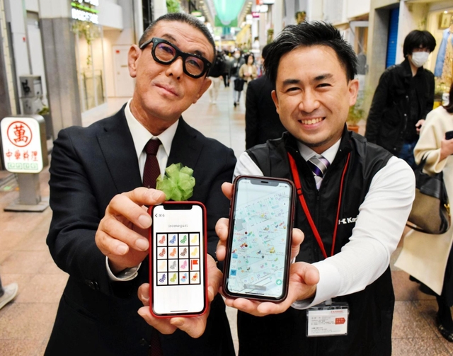 アプリ開発を担当した川崎重工業の永原斉さん（右）と三宮本通商店街振興組合の高井学代表理事＝神戸市中央区三宮町２