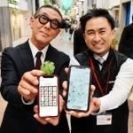 アプリ開発を担当した川崎重工業の永原斉さん（右）と三宮本通商店街振興組合の高井学代表理事＝神戸市中央区三宮町２