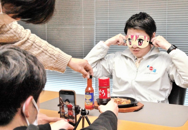 ＴｉｋＴｏｋ（ティックトック）用に目隠しをして動画撮影に臨むオリバーソースの道満龍彦取締役＝神戸市中央区港島南町３、同社