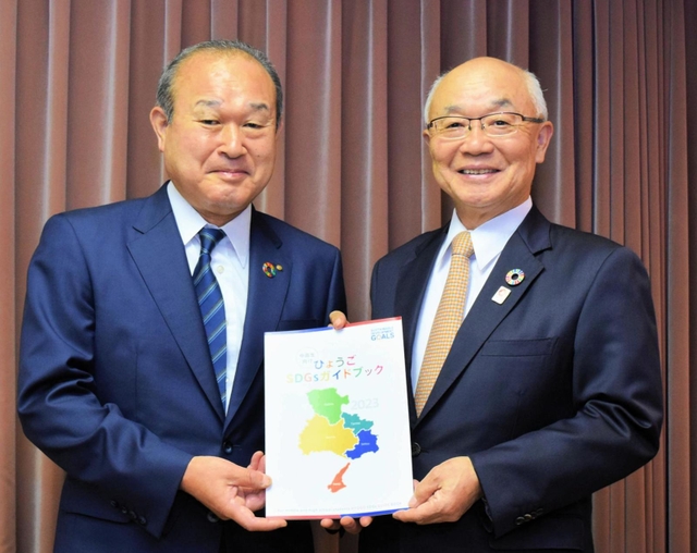 兵庫県内２行が初めて共同で作った冊子を手にする、但馬銀行の坪田奈津樹頭取（左）とみなと銀行の服部博明会長＝神戸市中央区三宮町２、みなと銀行本店