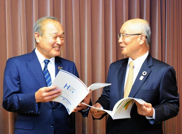 兵庫県内２行が初めて共同で作った冊子を手にする、但馬銀行の坪田奈津樹頭取（左）とみなと銀行の服部博明会長＝神戸市中央区三宮町２、みなと銀行本店