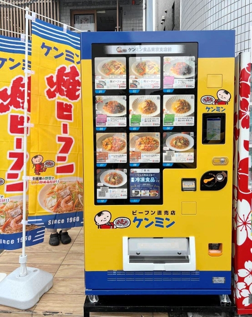 ケンミン食品東京支店前に設置された黄色と青の冷凍ビーフン自動販売機＝横浜市鶴見区汐入町１（同社提供）