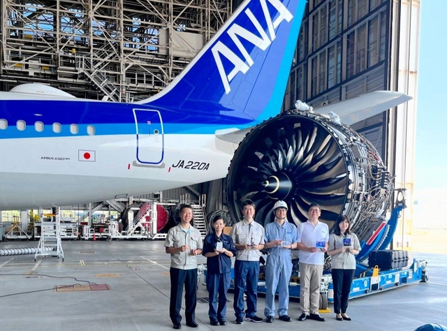 機体やエンジンを背にした、商品開発に携わった川崎重工業やＡＮＡホールディングスの社員ら＝羽田空港（川崎重工業提供）