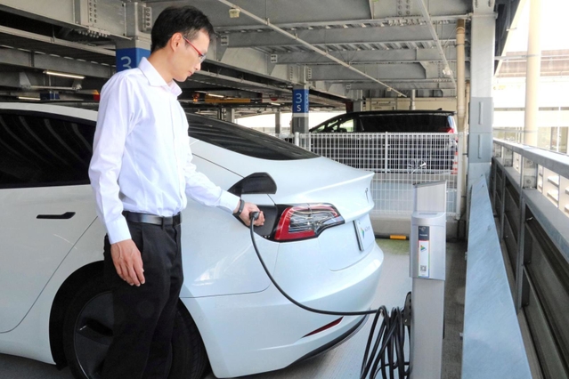 大阪空港の駐車場に導入される予定のＥＶ用コンセントを使った充電のデモンストレーション＝大阪府豊中市蛍池西町３、大阪空港