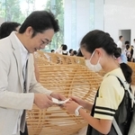 社員の子どもと名刺交換する鈴木信輝社長（左）＝神戸市中央区港島中町６、ワールド