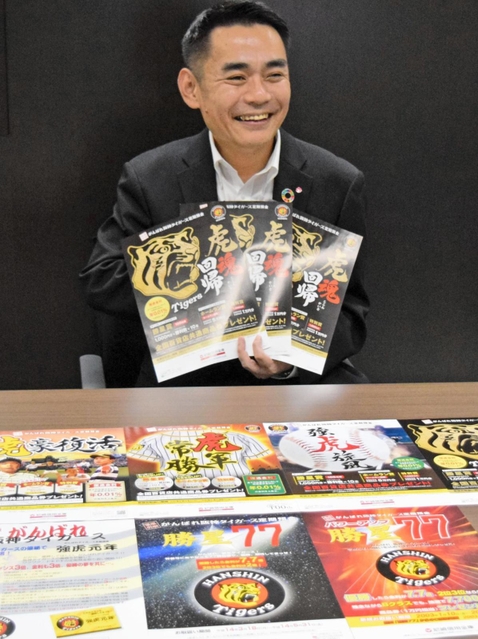 今年の募集チラシを手に、タイガース定期の全貌を解説する尼崎信用金庫の平山裕司担当部長＝尼崎市開明町３、本店