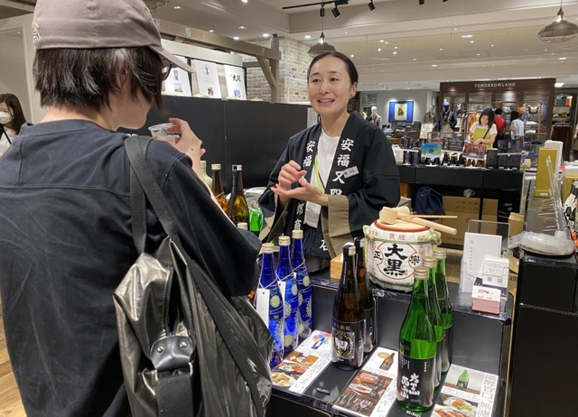 酒米「山田錦」を使った玄米茶について説明する安福又四郎商店の安福愛さん（右）＝神戸市中央区明石町、大丸神戸店