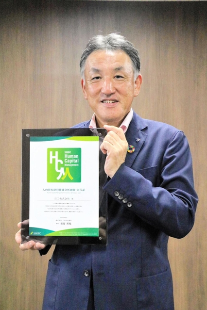 三井住友銀行から贈られた融資の実行証を手にする日工の辻勝社長＝明石市大久保町江井島