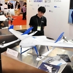 最長５０キロを飛行できる国産の「エアロボウイング」（手前）など最新のドローンが並んだ＝神戸市中央区港島中町６、神戸国際展示場