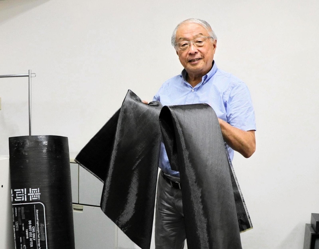 炭素繊維強化プラスチックをリサイクルしたクロスを手にする杉野守彦社長。今年のグッドデザイン賞を受賞した＝神戸市中央区小野柄通６、富士加飾神戸事務所