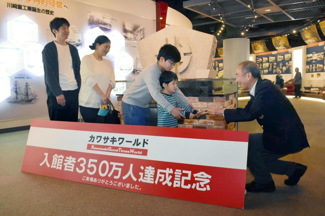 網川浩二ゼネラルマネジャー（右）から認定証を受け取る古谷さん家族＝神戸市中央区波止場町、カワサキワールド