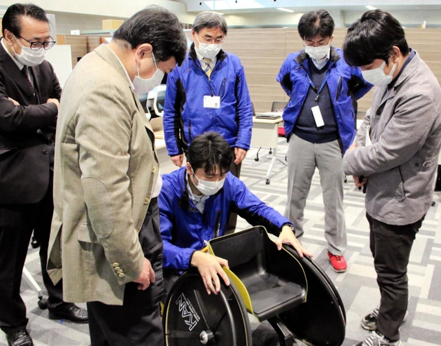 子ども用スポーツ車いすの最終試作車を確認し、改善点を議論する関係者＝神戸市西区曙町、県立福祉のまちづくり研究所
