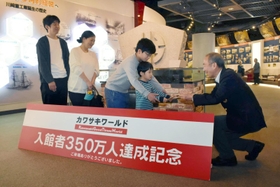 網川浩二ゼネラルマネジャー（右）から認定証を受け取る古谷さん家族＝神戸市中央区波止場町、カワサキワールド