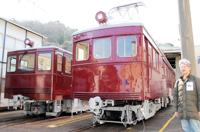 第１弾の修繕を終えた「デ１０１」（右）のお披露目会に出席する「デ１０１まもり隊」の米倉裕一郎さん。左の車両は後継の構内入換車＝２０２１年、神戸市北区鈴蘭台南町９、神戸電鉄鈴蘭台車庫