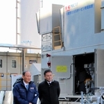 川崎重工業の金花芳則会長（右）の案内で、神戸・ポートアイランドの水素発電実証施設を視察する菅義偉前首相＝２５日午後、神戸市中央区港島中町８