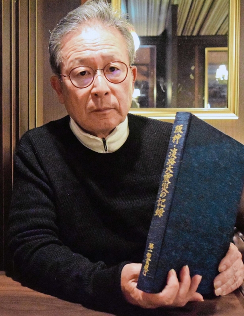 第一勧業銀行の「阪神・淡路大震災の記録」を手にする作家の江上剛さん。自身が編集を手がけた＝東京都杉並区