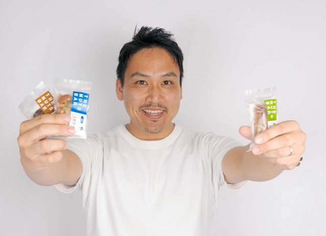 商品化した「ナッツバー」を持つシデカスの寄玉昌宏社長（本人提供）