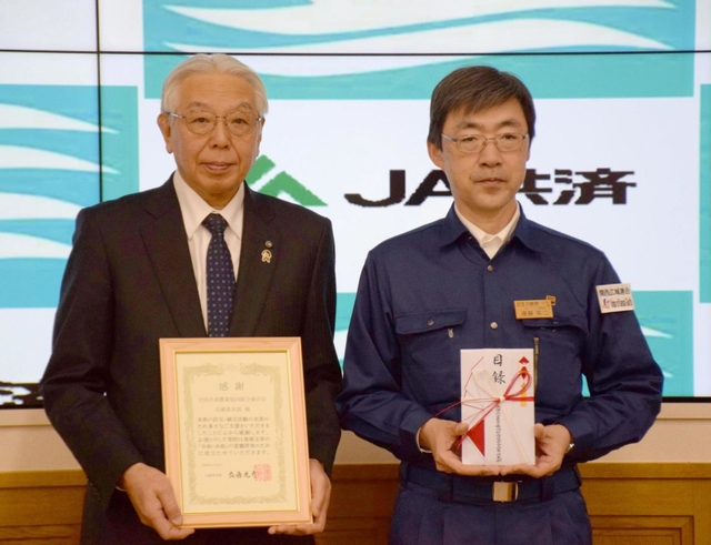 寄付目録を兵庫県に贈ったＪＡ共済連兵庫運営委員会の福本博之会長（左）と、県の遠藤英二防災監＝神戸市中央区、県災害対策センター