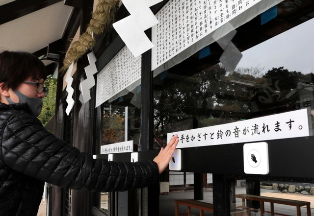 手をかざして鈴を鳴らす参拝客＝神戸市兵庫区和田宮通３