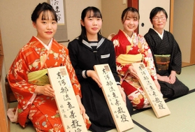 煎茶教授としての看板を手にする（左から）森本奈桜さん、佐藤瞳さん、樫原里奈さんと、師匠の河合翠風さん＝神戸市西区狩場台２