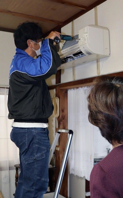 エアコンをクリーニングする葺合東専売所スタッフ＝神戸市中央区内