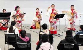 沖縄のグループ「うたばす」が奏でた楽曲に児童たちが聴き入った＝神戸市中央区、神戸空港