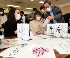 紙灯籠を製作する若者たち。震災のボランティアに携わった堀内正美さん（右）も作業に加わった＝神戸市長田区若松町５（撮影・中西幸大）