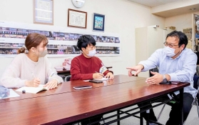 三宮センター街一丁目商店街振興組合の植村一仁副理事長（右）を取材する学生たち＝神戸市内（同市提供）