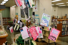 手に取らなくても見えるように小冊子を展示している田岡和也さんの作品展＝兵庫図書館