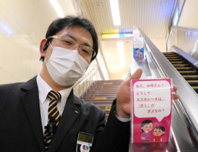 クスッと笑えるポップで、エスカレーターを歩かないよう呼び掛ける助役の北村尚三さん＝神戸市兵庫区、新開地駅