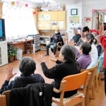 テレビ画面を見ながら体操をする高齢者＝神戸市長田区大橋町９