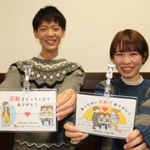 ベビーカープレートを手にする榊真緒さん（右）と武智尚也さん＝神戸市灘区六甲台町